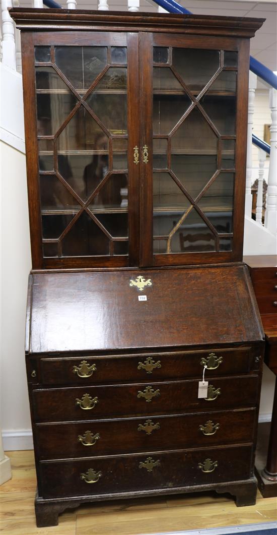 A George III oak bureau with associated bookcase top, W.95cm